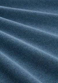 Textilgewebe in tiefblauer Farbe, das eine strukturierte Webart mit sichtbaren diagonalen Rillen und glatter Oberfläche aufweist.