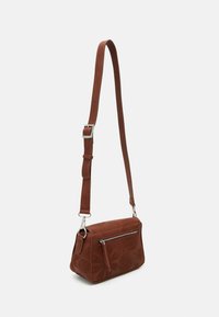 Borsa a tracolla in faux leather marrone con motivi floreali in rilievo, hardware in tono argento e una tasca frontale con zip. Cinghia regolabile.