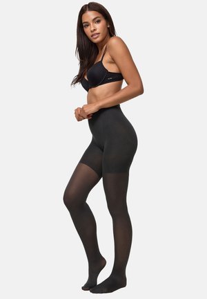 Medias opacas negras con una textura suave, diseño de cintura alta y abertura en los dedos, usadas por un modelo sobre un fondo neutro.