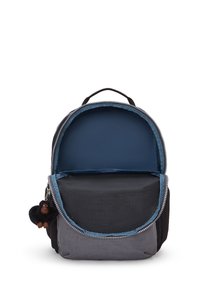 Schwarzer und grauer Rucksack mit runder Form, silbernem Reißverschluss, weicher Textur und innerem blauen Futter. Enthält einen abnehmbaren schwarzen Affenanhänger.