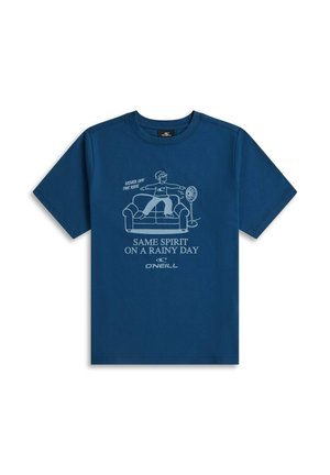 Blauw T-shirt met een afbeelding van een persoon die binnen op een bank naast een ventilator skateboardt, met tekst "Same spirit on a rainy day."