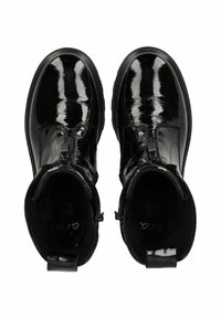 Botines de charol negro con un acabado suave, que cuentan con un cierre lateral, punta redondeada y un forro interior suave.