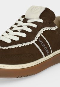 Baskets en daim marron avec bordure blanche festonnée, lacets blancs et "VALENTINO" imprimé sur le côté, avec une semelle en gomme.