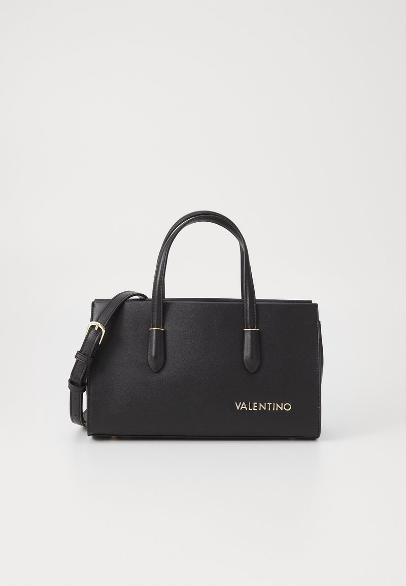 Černá kožená kabelka s krátkým a odnímatelným popruhem přes rameno, zlaté logo na přední straně, hladká textura, obdélníkový tvar, minimalistický design.