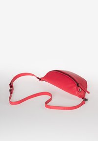 Borsa a tracolla rossa in pelle con forma curvata, chiusura con zip e tracolla regolabile. Texture liscia con dettagli hardware minimi.