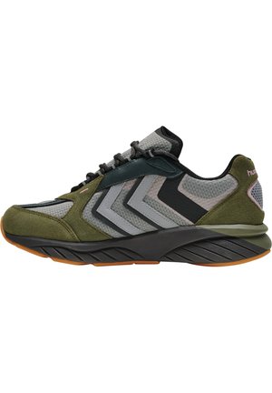 Sneaker med en overdel i grøn ruskind og grå mesh, der har et chevron-mønster, sorte accenter og en struktureret sort sål med en tan ydersål.