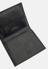 Portefeuille en cuir véritable noir avec plusieurs emplacements pour cartes, texture lisse et fonctionnalité de protection RFID. L'intérieur présente le logo de la marque.