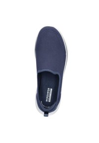 Zapato slip-on de Skechers con un верх текстurizado de malla en color azul marino, entresuela blanca y una lengüeta en el talón para facilitar su puesta.