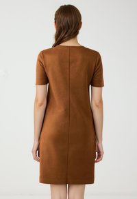 Braunes, kurzes Kleid aus Kunstwildleder mit kurzen Ärmeln und runder Ausschnittform. Es verfügt über eine zentrale Naht auf der Rückseite und hat eine glatte Textur.