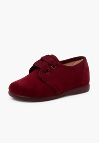 Scarpa in suede rosso con punta rotonda, caratterizzata da un semplice design con lacci e una texture morbida. La piccola suola in gomma bassa offre comfort.