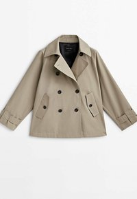 Beige kaksirivinen lyhyt trenssitakki, jossa leveä kaulus, mustat napit, napilliset läppätaskut ja napilliset hihansuut.