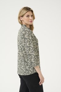 Schwarze und cremefarbene Bluse mit floralem Muster und Mandarin-Kragen. Sie verfügt über einen Druck von kleinen Blumen, drei Viertelärmeln und einem leichten Stoff.