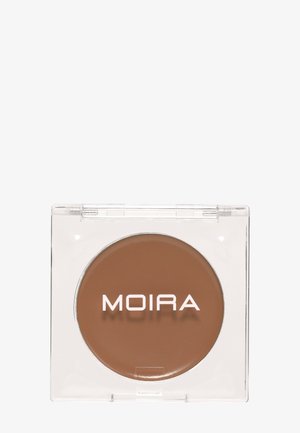 Kompakt gennemsigtigt etui med brun creme-makeup mærket "MOIRA" placeret på hvid baggrund.