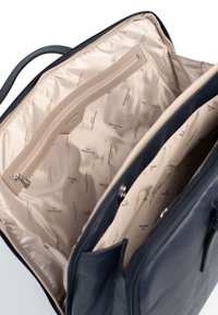 Interno di una borsa in pelle blu navy con fodera beige chiaro, dotato di una tasca con zip e più scomparti, impresso con "HEXAGONA PARIS."