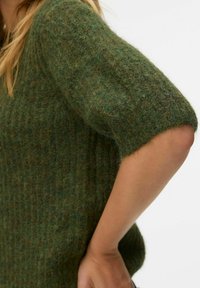 Zielony sweter z krótkimi rękawami, wykonany z teksturowanego, miękkiego materiału o luźnym kroju. Tkanina wykazuje subtelne różnice w odcieniach koloru.