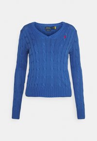 Blå kabelstickad tröja med v-ringning, långa ärmar och ribbad nederkant. Har en liten röd logo på vänster bröst.