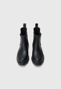 Black leather ankle boots with a smooth finish, elastic side panels, and pull tabs for easy wear. Rubber soles provide traction.