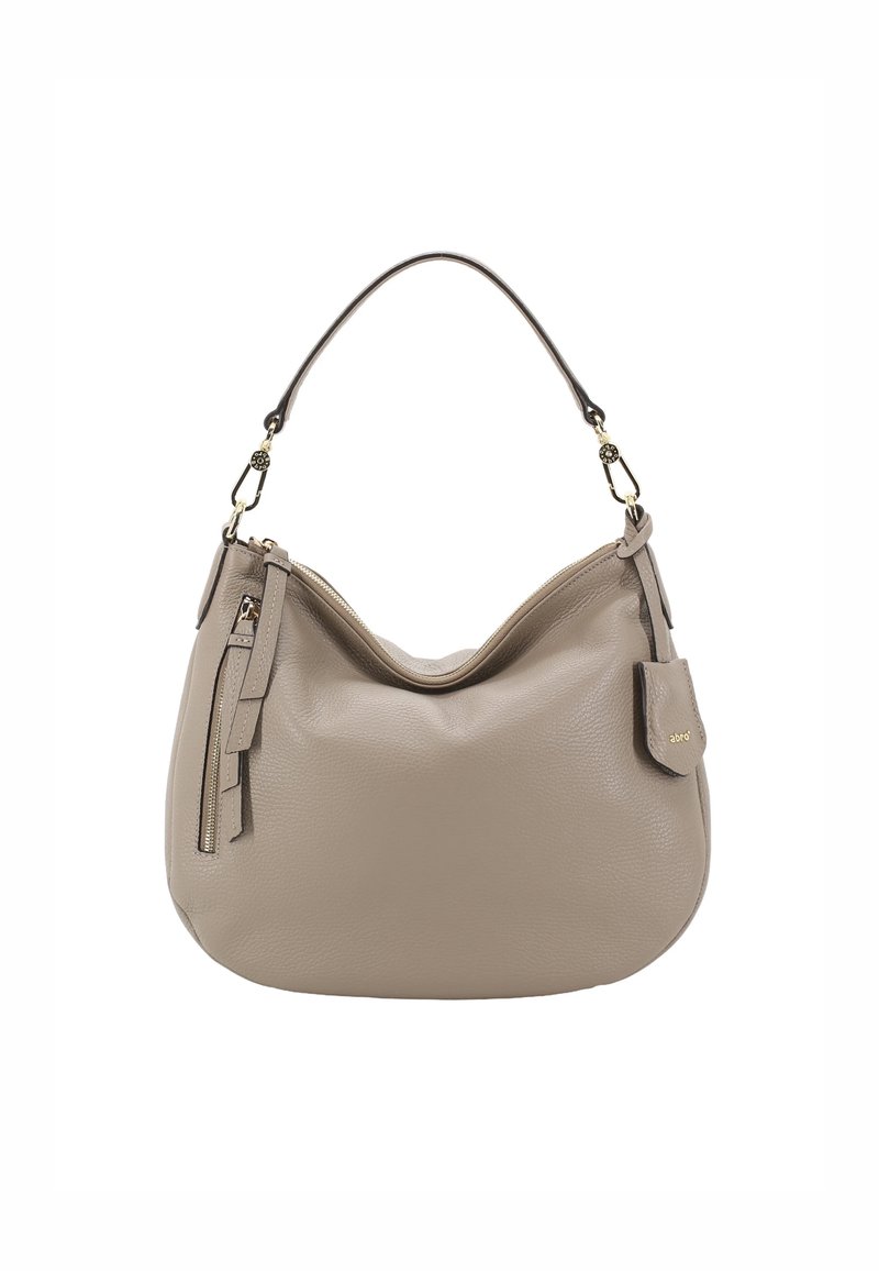 Sac à épaule en cuir beige avec une forme incurvée, une courte poignée, une poche zippée et un pompon décoratif. Accents en métal doré.