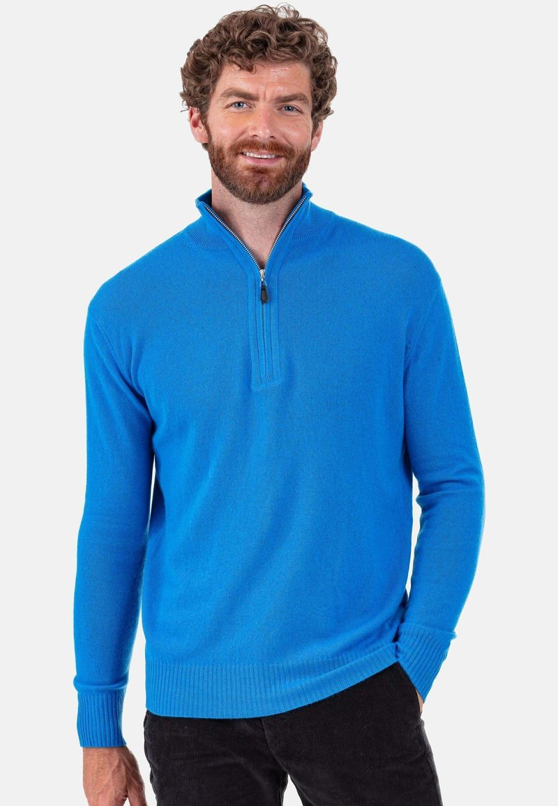 Pull-over bleu de poids moyen avec un col demi-fermeture éclair, poignets et ourlet côtelés, présentant une texture lisse et une coupe ajustée.