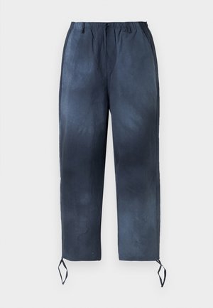 Tumesinine paeltega püksid elastse vöökohtuga, kahe külgeheitega tasku ja pahkluude seotavatega, esitatud valge tausta ees.