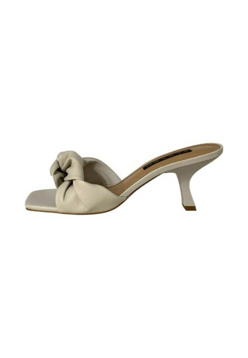 Mule beige con tacco alto, con un accent di tessuto annodato, punta quadrata e un tacco sottile e angolare. Texture liscia con un design minimalista.