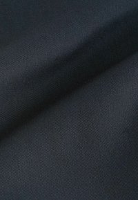 Schwarzer Stoff mit einer feinen gewebten Textur, die eine glatte Oberfläche und einen dezenten Glanz aufweist. Das Material wirkt robust und fest gewebt.