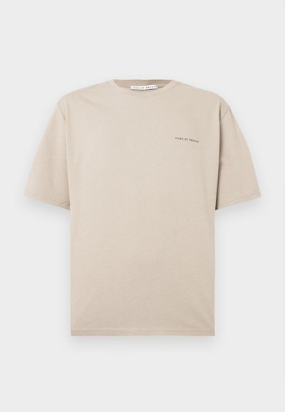 Beidge īsām piedurknēm T-krekls, izgatavots no mīksta kokvilnas, ar klassisku komandu kaklu un minimālistisku melnu "Tiger of Sweden" logotipu kreisajā krūtī.