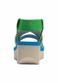 Sandali in tessuto verde con accenti blu, dotati di una spessa suola bianca, apertura sul retro e cinture incrociate, progettati per comfort e supporto.