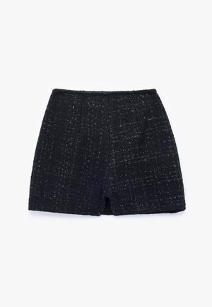 Pantalones cortos de tweed negro con un tejido texturizado, que presentan un corte recto y una cintura de altura media. Sin cierres visibles, bordes limpios.
