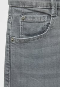 Gray denim fabric featuring a front pocket with metal hardware. The texture is smooth with a subtle, light-washed appearance.