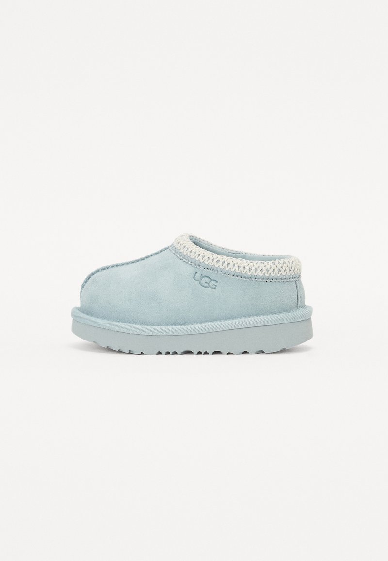 Ljusblå mocka slip-on sko med en texturerad stickad krage och en låg gummisul. Har en rund tå och subtil märkning på sidan.