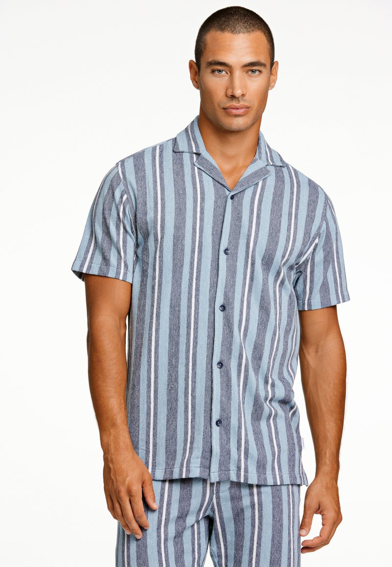 Camicetta a maniche corte con bottoni, blu con strisce verticali scure, tessuto leggero, design del colletto, cinque bottoni, pantaloni corti abbinati visibili.
