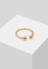 Guldring med et åbent design, der har to sfæriske accenter i hver ende. Glat, shiny finish med en rund form.