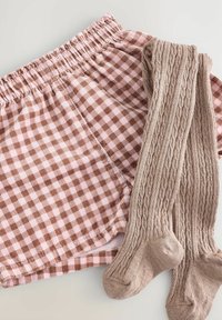 Pantaloni corti a quadri in tessuto marrone e rosa, abbinati a collant beige a maglia. Entrambi presentano una cintura elastica e una consistenza morbida.