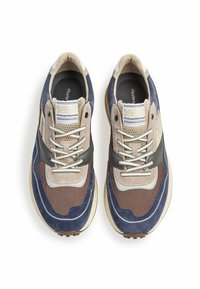 Sportschuhe aus einer Kombination von braunem Wildleder, beigem Mesh und marineblauen Akzenten. Weiße und graue Markenkennzeichnung, strukturierte Sohle mit mehreren Grip-Punkten.