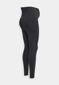Leggings noirs avec une taille haute, dotées d'un tissu lisse et extensible et de coutures contrastantes sur les côtés pour un détail supplémentaire.