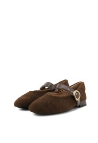 Scarpe slip-on in lana marrone con punta affusolata e una larga fascia in pelle marrone con dettagli in metallo dorato. Suola piatta con tacco minimo.