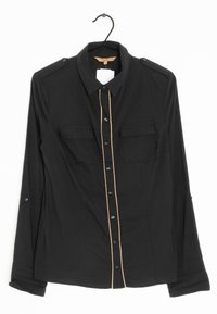 Maglietta nera a maniche lunghe con chiusura a bottoni, due tasche sul petto, spalline sulle spalle e una linea beige a contrasto lungo il centro.