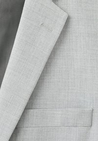 Lysegrå jakkesætjakke med subtilt ternet mønster, der viser revers og detaljer ved brystlomme.