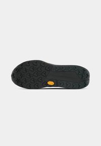 Black rubber shoe sole with a textured, gripping pattern and a yellow reinforced accent. Features spaced heart-shaped lugs for traction.