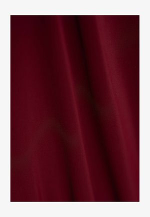 Bordeauxfarbener Stoff mit einer glatten, matten Textur, der sanfte Falten zeigt und durchgehend eine einheitliche Farbe aufweist, ohne sichtbare Muster oder Akzente.