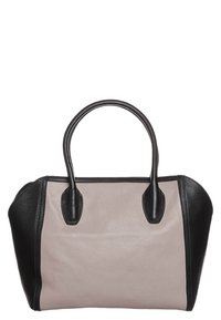 Skórzana torebka z jasnoróżowym centralnym panelem i czarnymi teksturowanymi bocznymi panelami. Posiada dwa czarne uchwyty i ustrukturyzowany, zaokrąglony kształt.