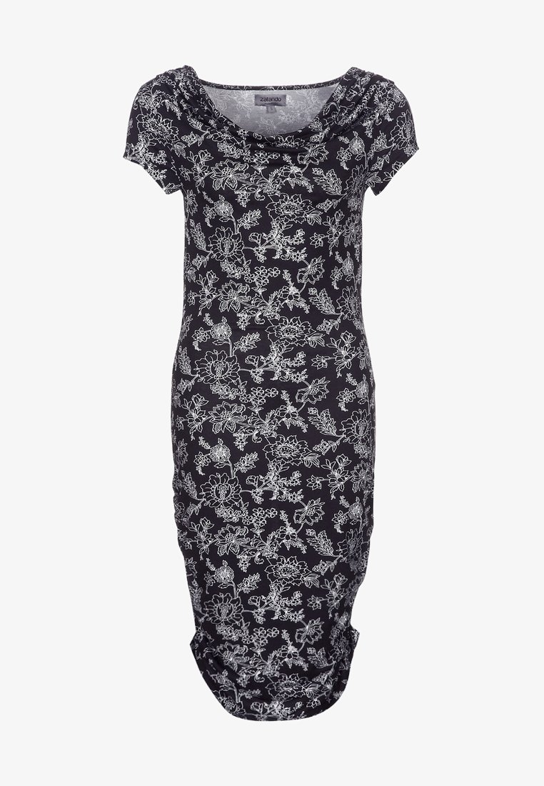 Robe noire longueur genou avec motif floral blanc, manches courtes et encolure drapée.