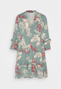 Robe fleurie en tissu vert doux avec un décolleté en V, des manches à volants et des niveaux. Présente des papillons roses et bordeaux ainsi que des feuilles.