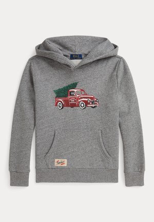 Sudadera con capucha gris con bolsillo frontal, con un gráfico de un camión rojo vintage que lleva un árbol de Navidad verde y una pequeña etiqueta cerca del bolsillo.