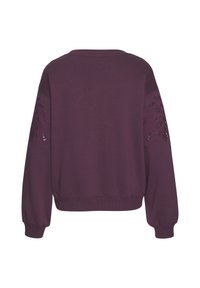 Sudadera burdeos de manga larga, con puños acanalados y bordado floral texturizado en ambas mangas. Tela suave, ajuste holgado.