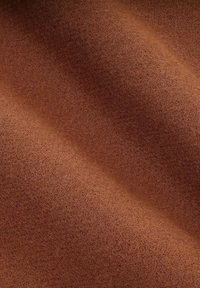 Brązowy filc o gładkiej teksturze i miękkiej, lekko puszystej powierzchni, z subtelnymi różnicami w odcieniu i jednolitości.