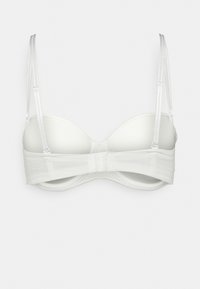 Balts polsterēts krūšturis ar regulējamām plecu siksnām un sprādzi aizmugurē, attēlots no aizmugures uz vienkārša fona.