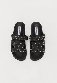 Schwarze Sandalen mit Nietenakzenten und zwei Riemen auf der Oberseite. Glatte Gummisohle mit flachem Design. Markenlabel innen sichtbar.