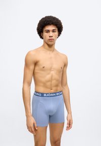 Ανοιχτό μπλε ανδρικά μπόξερ briefs από ελαστικό ύφασμα, με σκούρο μπλε ελαστική μέση που φέρει το λογότυπο "BJÖRN BORG". Στενή εφαρμογή με επίπεδα ραφές.